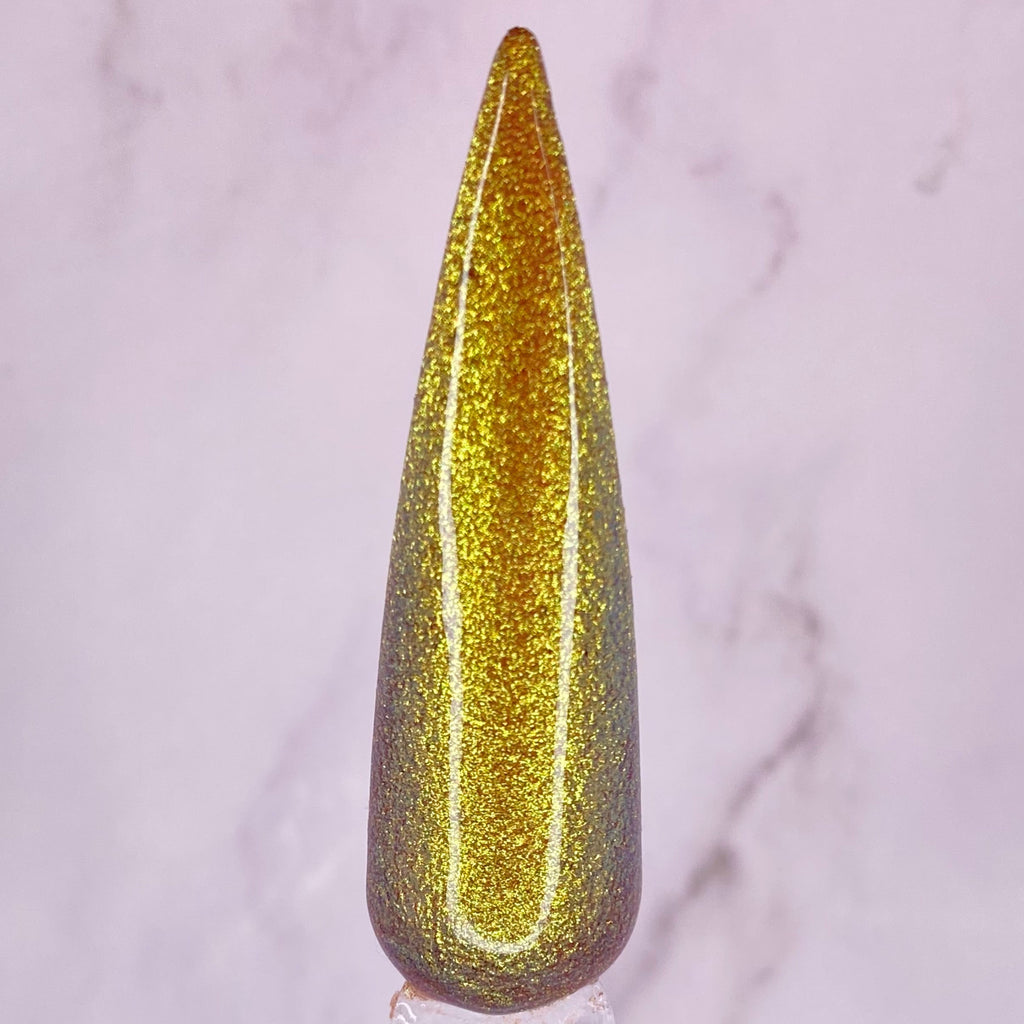 Gold glittery nail tip on a light marble background
